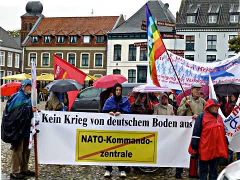 Demonstration mit Fahnen und Transparent: »Kein Krieg von deuschem Boden aus« und durchgestrichen: »NATO Kommandozentrale«.
