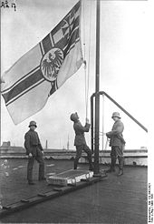Auf einem Dach: Soldaten beim Hissen der Kriegsflagge der Kaiserlichen Marine, März 1920.